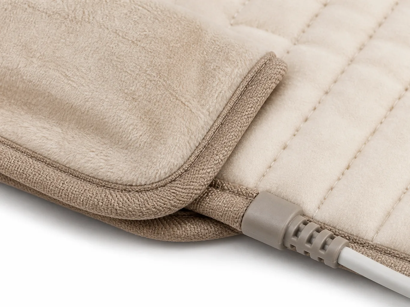 Close-up of the quilted element channels, bound corner, closed control flap and moulded strain-relief cord boot