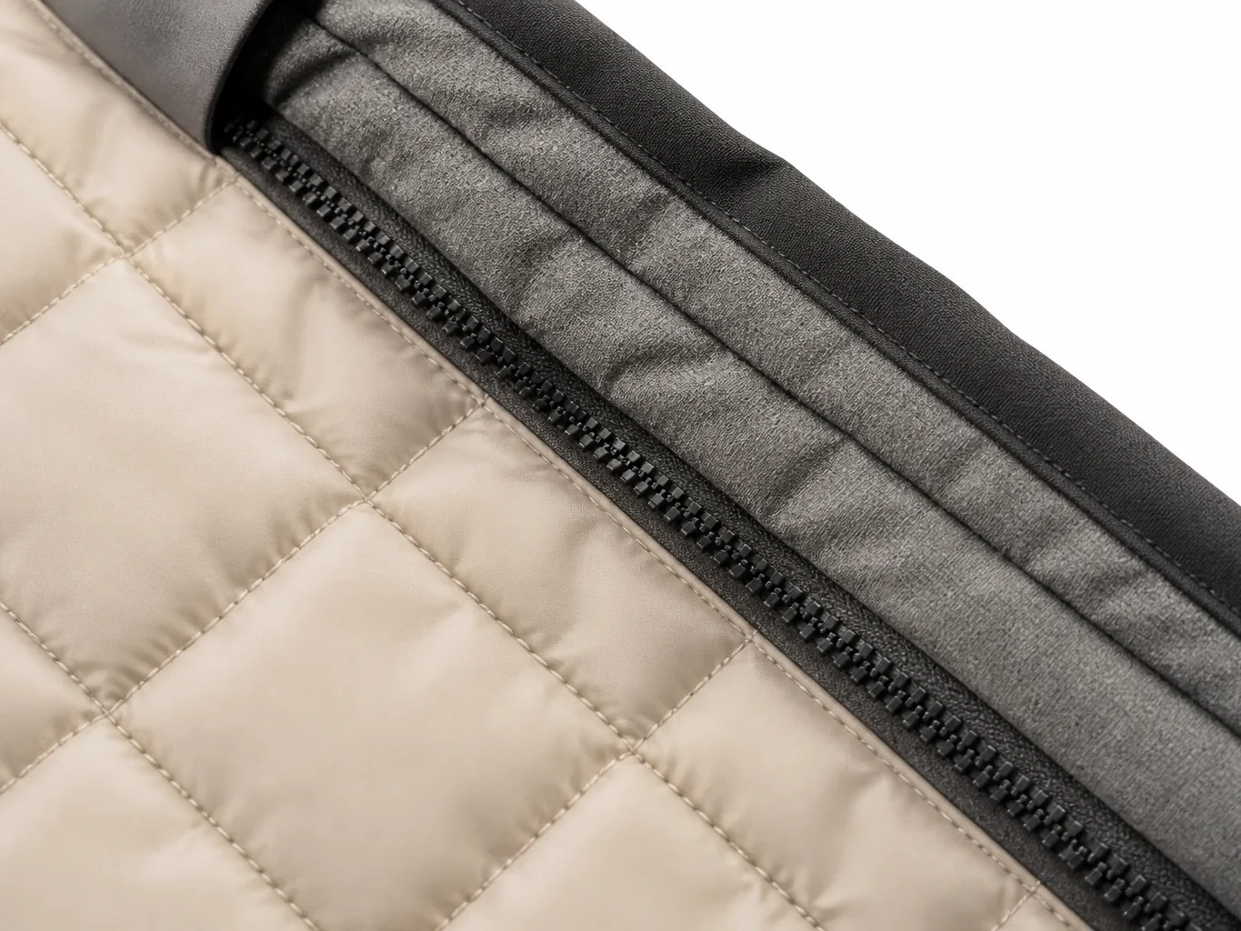 Close-up of a heated vest inner panel showing quilted heat-panel stitching and the concealed wiring channel