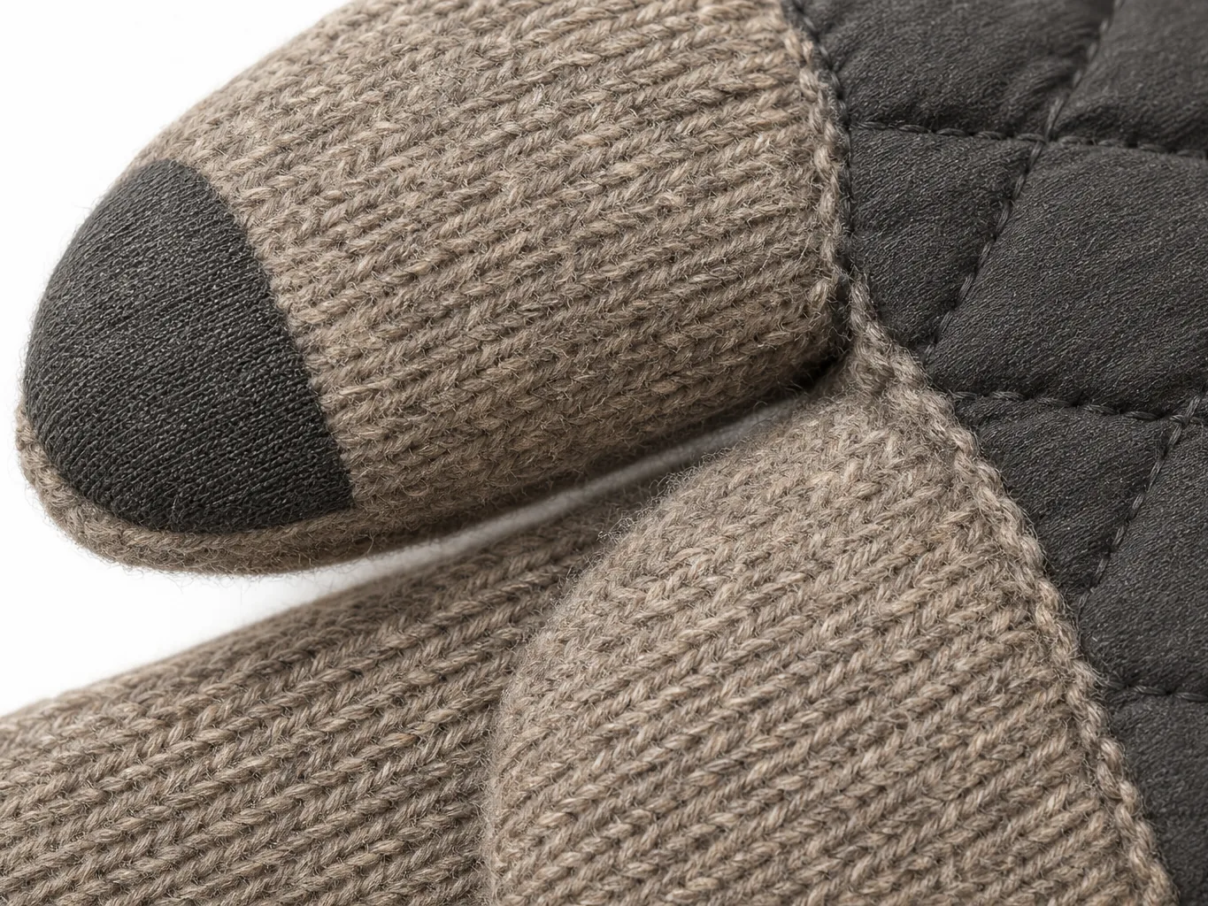 Close-up of a heated glove fingertip showing the conductive touchscreen treatment and quilting