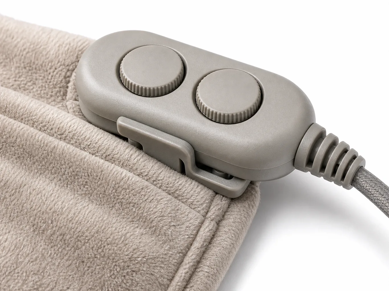 Close-up of the dual-zone controller clipped to the poncho pocket, showing two dials and the strain-relieved cord