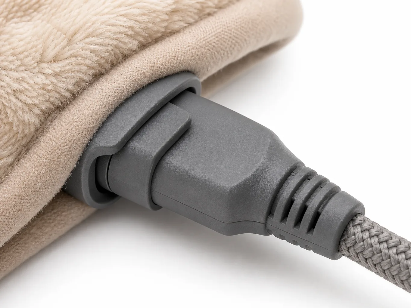 Close-up of the cord connection showing the moulded plug seated in the hem socket with its locking retention clip and strain relief