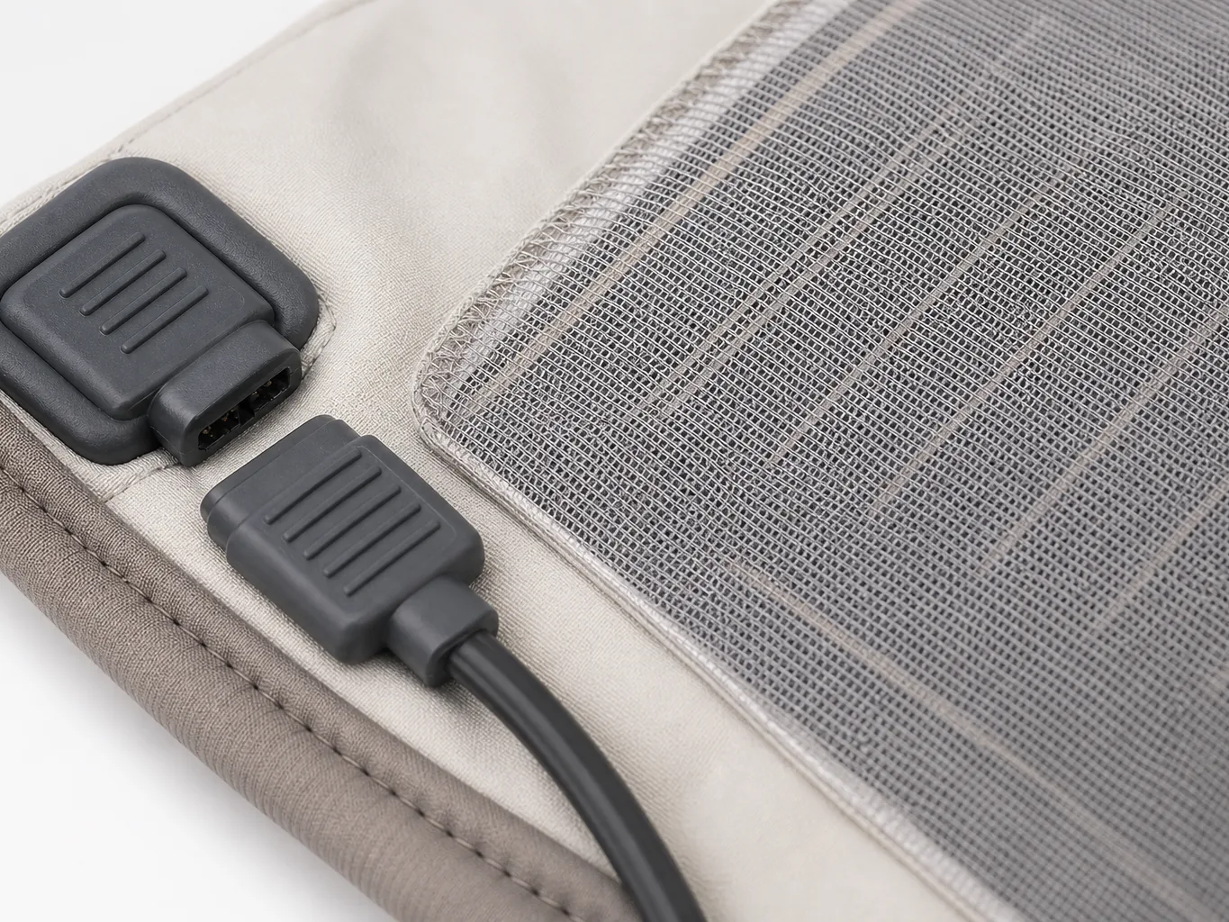 Close-up of the inside of the vest showing the laminated heating panel, mesh lining and the sealed detachable connector