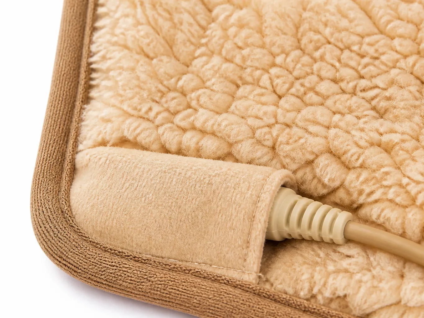 Close-up of the sherpa pile corner, bound edge, covered battery pocket flap and the moulded strain-relief cord boot entering it